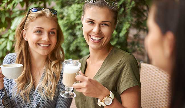 A group of women enjoying a nice, hot cup of coffee.