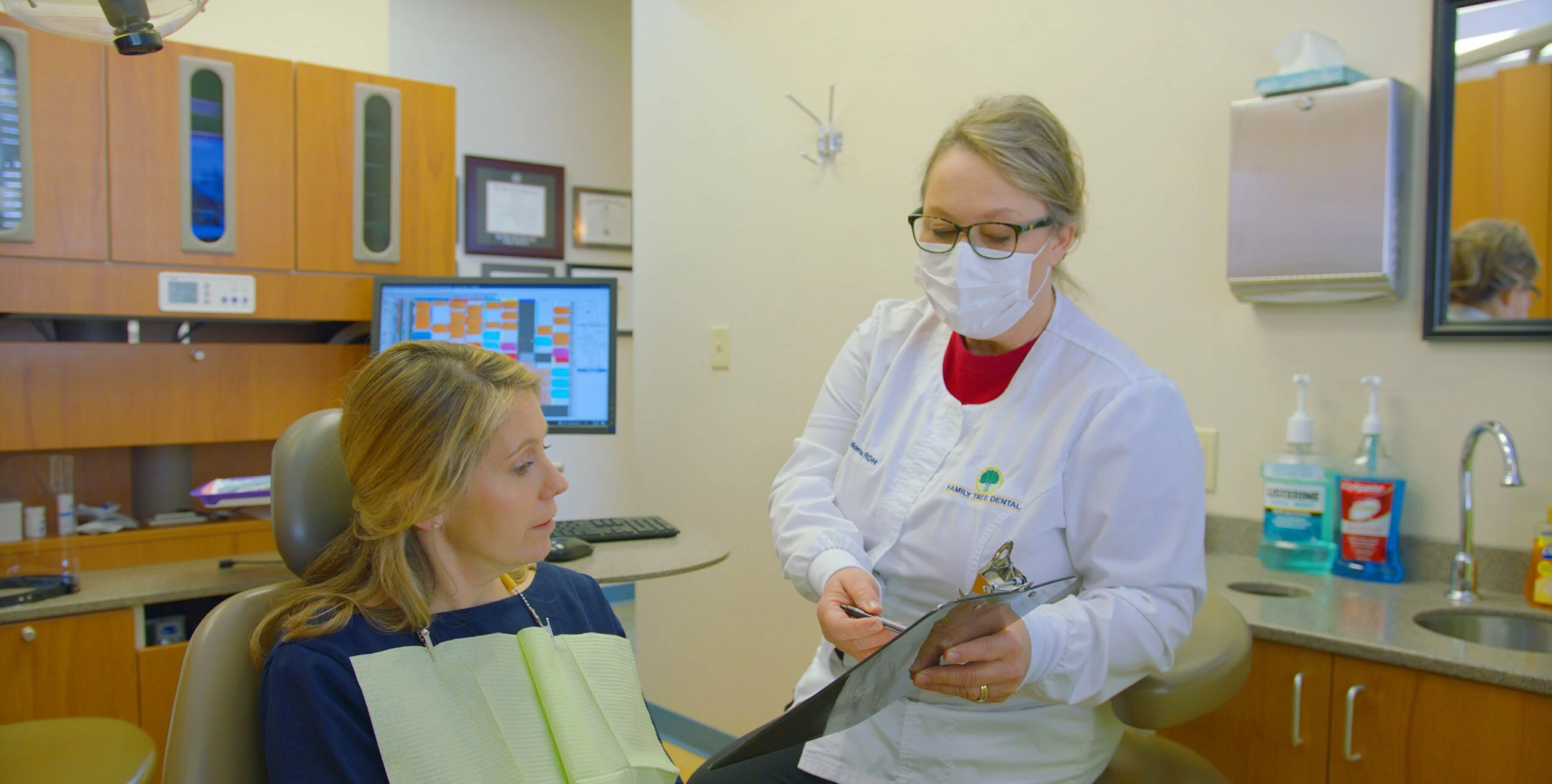 Family Tree Dental hygienist reviewing a chart with a patient in Marietta, OH
