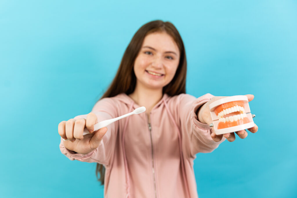 Dental Beautiful smiling of young woman with retainer braces glad emotion with white teeth increase confidence for healthy on blue background isolated, Happy funny teen girl brush her teeth, healthy concept,