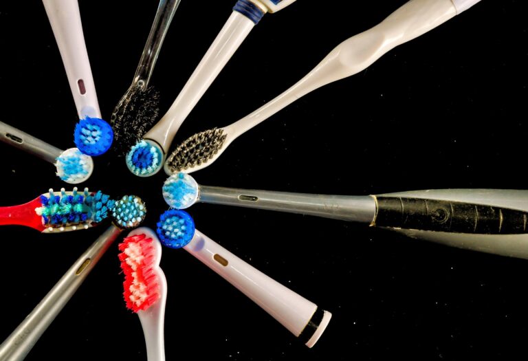 A high angle closeup shot of electric toothbrushes on a black background